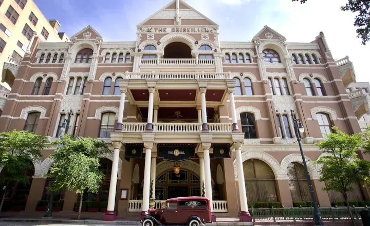 Large historic building with vintage car.