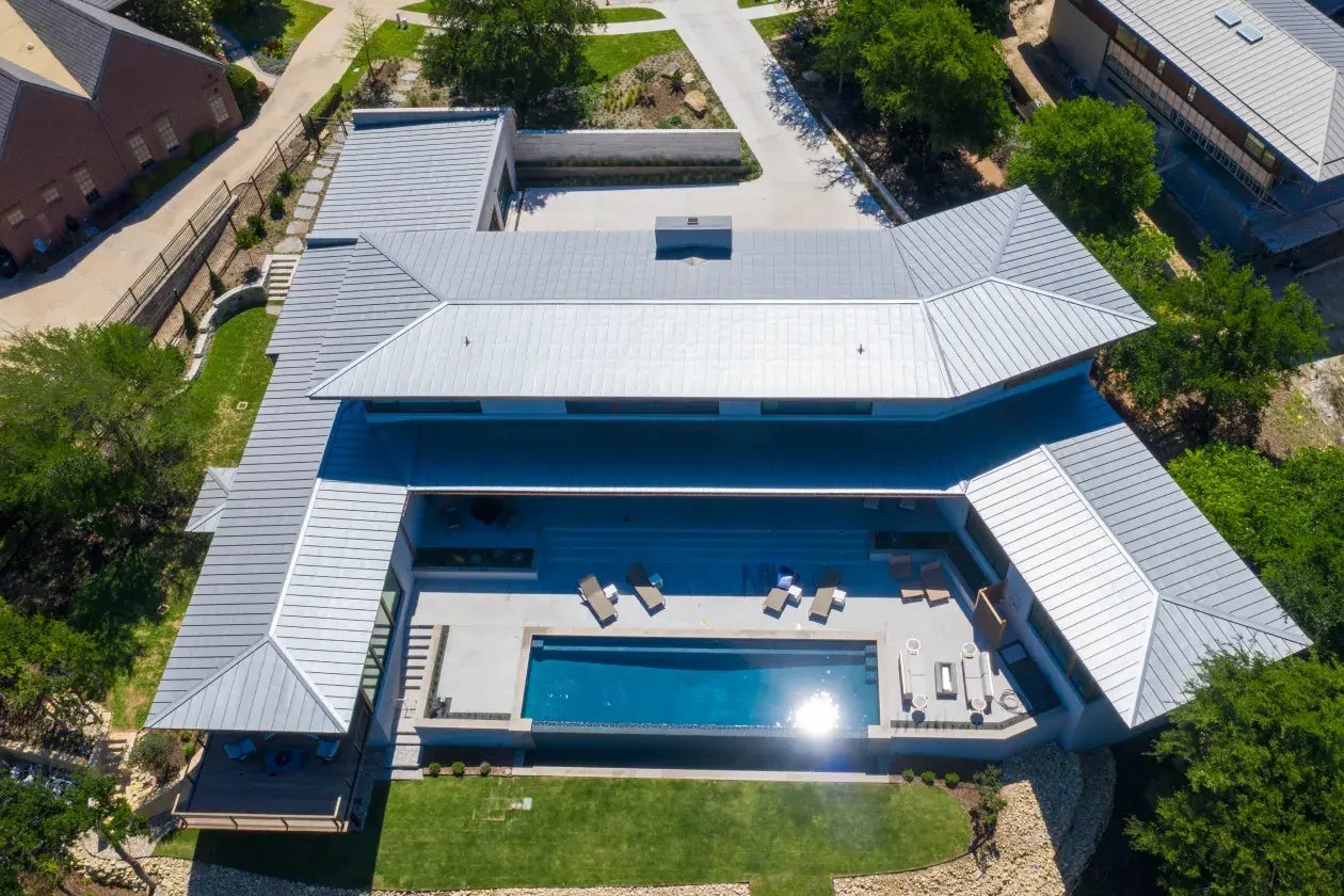 Mansion with metal roof and backyard pool. 