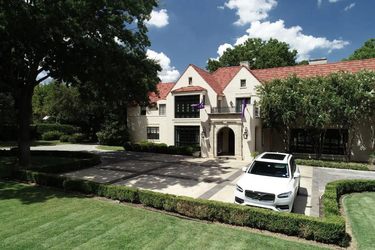 Facade of large home with driveway.